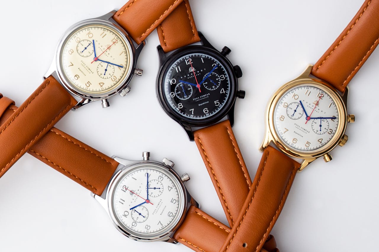 A stylish flat lay of vintage wristwatches with leather straps on a white background.